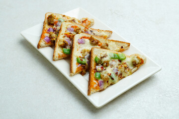 Bread Pizza or pizza toast topped with cheese, chicken and vegetables
