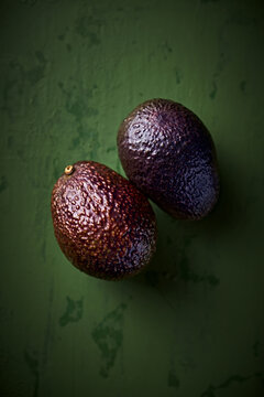 Hass avocado on green rustic background. Top view