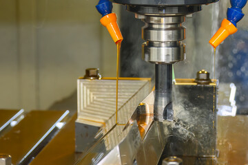 The CNC milling machine rough cutting the mold parts with liquid coolant method.