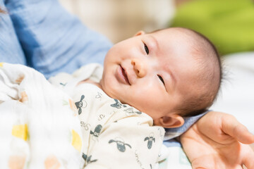 母親に抱かれてお昼寝する赤ちゃん