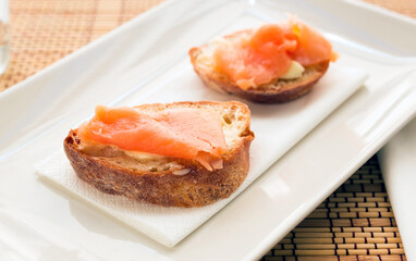 Delicious canapes of salted smoked salmon fillet on slices of fresh ciabatta bread
