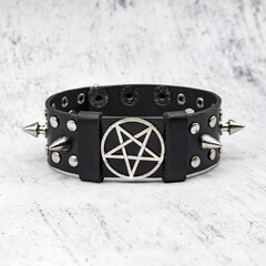 Black leather bracelet with spikes, holnitenes and a pentagram. An accessory for rockers, bikers,...