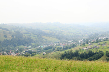 Landscape of Zakarpattia Oblast, Ukraine, Yasinya, view from the hill. Fog in the Carpathians, houses and plots