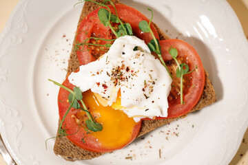 Plate of tasty sandwich with egg on yellow background