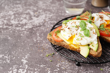 Grid of tasty sandwiches with egg on grey background