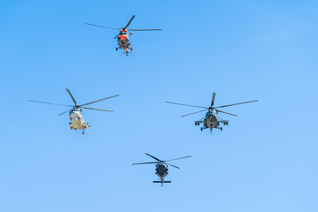 Fototapeta premium Multiple helicopters flying in formation on a clear blue day