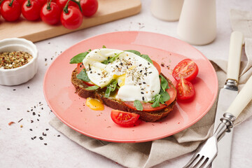 Plate of tasty sandwich with egg on light background