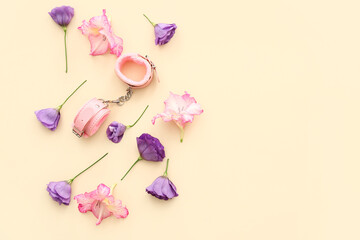 Composition with beautiful flowers and sex toys on beige background