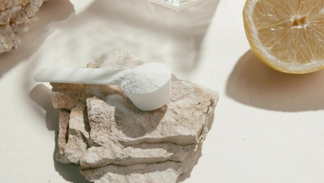 Sport supplement, creatine, hmb, bcaa, amino acid or vitamin measure with powder in a lifestyle contest. 4k high quality video. Sport nutrition health and food concept. Dry flowers, stones and shadows