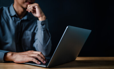 laptop, typing, close up, hand, businessman, portrait, background, blue, keyboard, formal. picture is portrait close up to businessman, him typing at keyboard on laptop in a serious way for something.