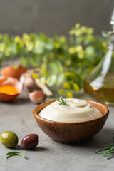 Bowl of Homemade mayonnaise sauce with olives, ingredients and herbs for cooking
