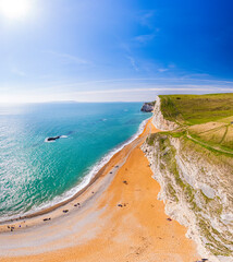Fototapeta na wymiar Aerial view of golden beach and white cliffs along Dorset Jurassic Coastline. UK