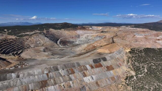Aerial copper gold open pit mine Ely Nevada. Boom town along historic Pony Express trail. Rural mining community. Ore transported to Japan for smelting. Precious minerals.
