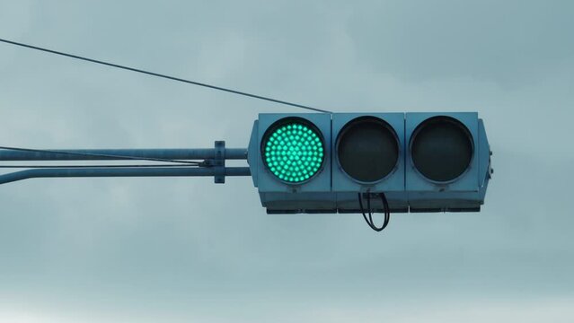 曇り空と信号機：信号が赤から青へ変わる様子	