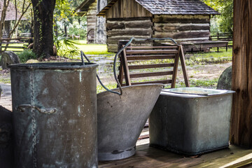 Antique buckets and pails with cabin.