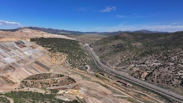 Aerial gold copper mine to mountain Ely Nevada. Boom town along historic Pony Express trail. Rural mining community. Ore transported to Japan for smelting. Precious minerals.