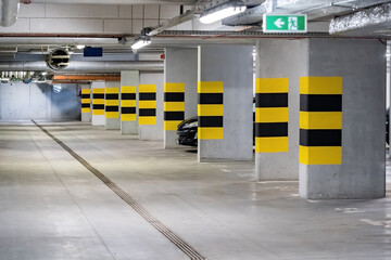 Empty underground parking lot under a modern apartment complex flat, one generic car parked,...