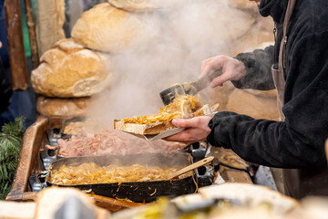 Man preparing a large slice of bread with delicious onions and lard traditional food festive market stall detail lots of different types of food being sold buying selling natural organic food products