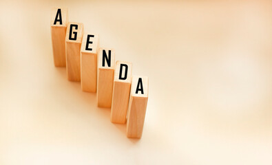 Word AGENDA. Wooden cubes with letters isolated on a light background.