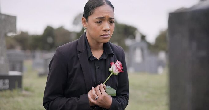 Sad woman, rose and graveyard in loss, grief or mourning at funeral, tombstone or cemetery. Female person with flower in depression, death or goodbye at memorial or burial service for loved one