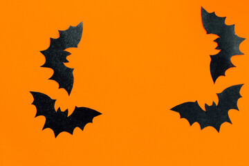 Paper bats on an orange background, Halloween concept