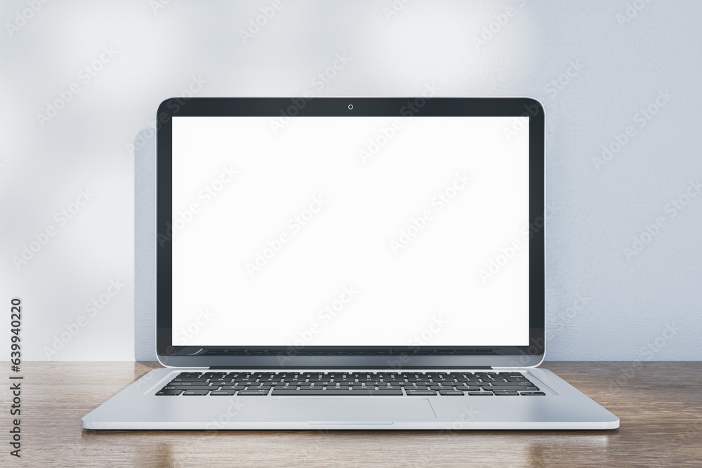 Poster Close up of laptop with empty white mock up screen placed on wooden desk. Concrete wall with shadows in the background. 3D Rendering.