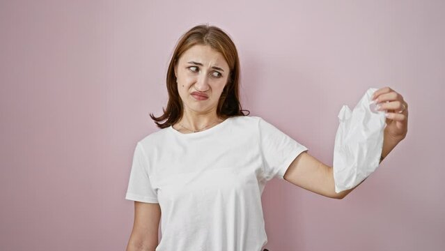 Young woman asking for use paper bag over isolated pink background