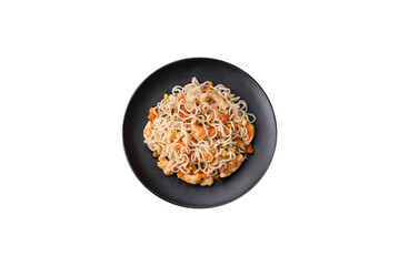 Delicious noodles with chicken and vegetables or udon on a black ceramic plate