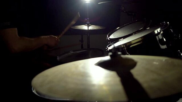 Expressive musician artist man drummer is playing hitting drums and cymbals.