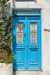 Fototapeta na wymiar Traditional wooden light-blue door at the picturesque village of Plomari in Lesvos island, northern Aegean Sea, Greece, Europe.