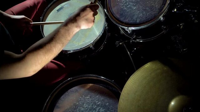 Top view of hands of rock musician drummer playing hitting drums and cymbals.
