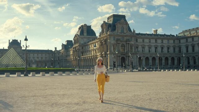 Happy young girl walking in the Louvre Square in Paris