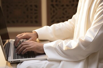 close up of hands of a Muslim businessman in white clothes typing on a laptop