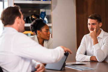 Fototapeta premium Male mature caucasian ceo businessman leader with diverse coworkers team executive managers group meeting. Multicultural professional businesspeople working together on research plan boardroom.