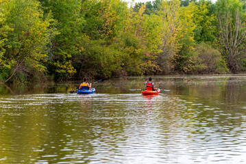 Fototapeta na wymiar A Couple Kayaking On The River In Early September In Wisconsin