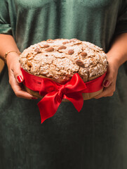 Panettone Italian Christmas dessert, sweet bread, hands holding sweet gift.