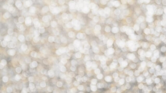 Abstract silver background, motion blurred silver lights, bokeh effect. Futuristic glittering in space. Christmas, New Year or any other holiday or party background.