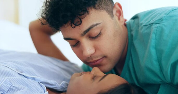 Kiss, love and couple in bed relax, bond or intimate in their home with romance, connection or rest together. Kissing, intimacy and man with woman in bedroom with desire, happy and smile with passion