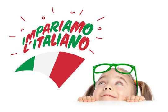 Beautiful cute little girl hiding under table and curiously looking at "Let's learn Italian" text and Italy flag above her head.