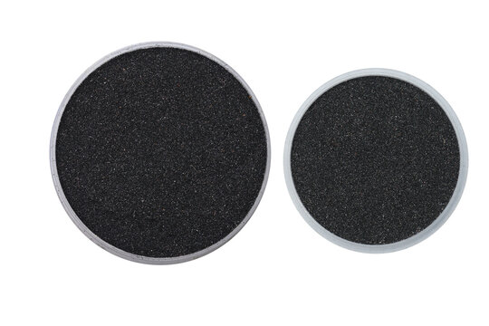 Specimens of milled Ilmenite mineral sand on small trays on isolated white background