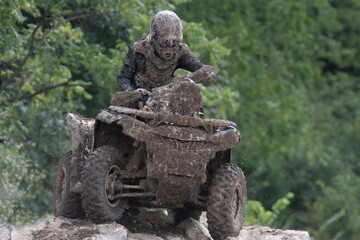 Mud-covered ATV Rider Climbs Over Rocks © Michael Rolands
