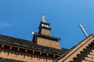 Low angle view of a 20th century wooden built church steeple in the Norwegian stave architectural style, with blue sky background