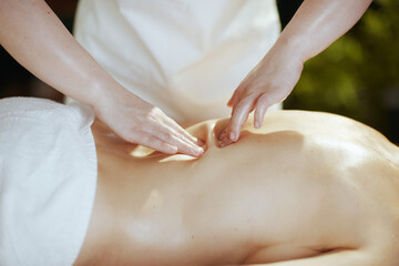 Medical massage therapist in spa salon massaging client