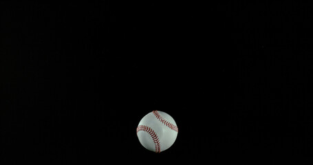 Ball of Baseball breaking Pane of Glass against Black Background