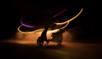 Silhouette scooter standing on table in low key. Selective focus
