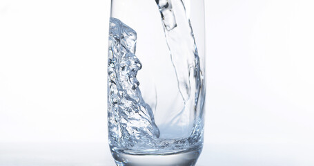 Water being poured into Glass against White Background