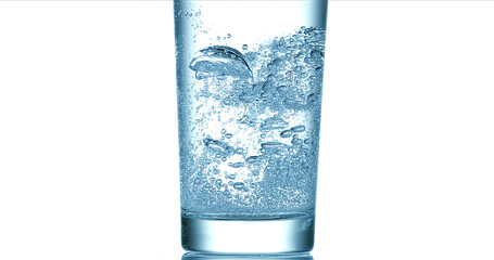 Water being poured into Glass against White Background