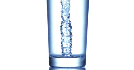 Water being poured into Glass against White Background