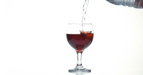 Red Wine being poured into Glass, against White Background