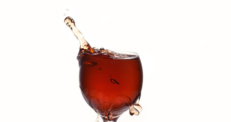 Tablet Falling into a Glass of red Wine against White Background